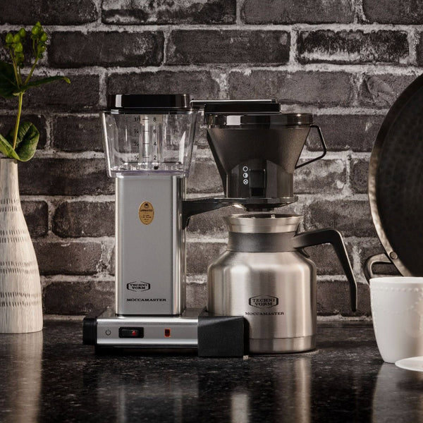 Lifestyle Moccamaster KBTS Coffee Maker in Polished Silver against a brick wall